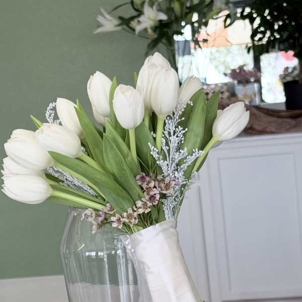 White tulip bouquet with small pink filler flowers and a matching boutonniere