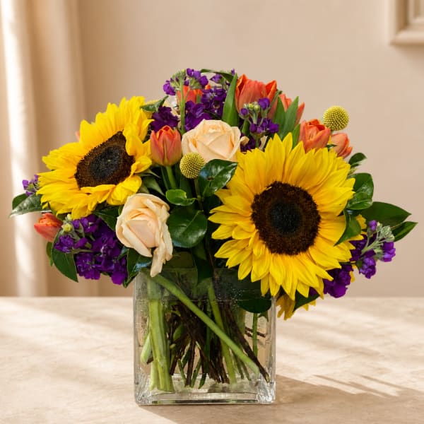 Sunflower and rose bouquet in a clear glass vase