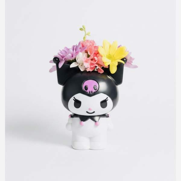 Small character figurine topped with colorful flowers