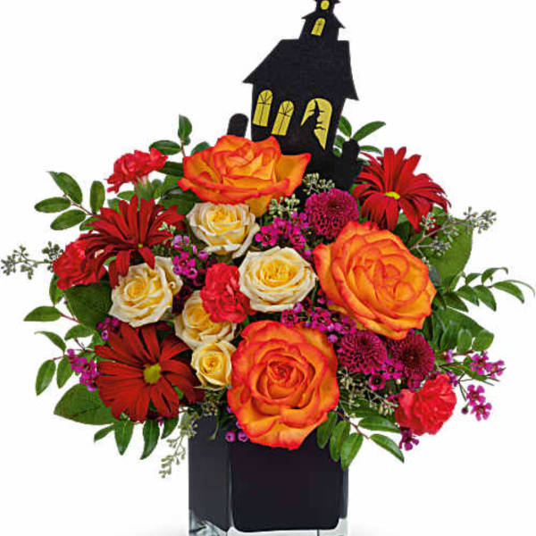 Halloween bouquet with orange and red roses in a black vase with a haunted house pick