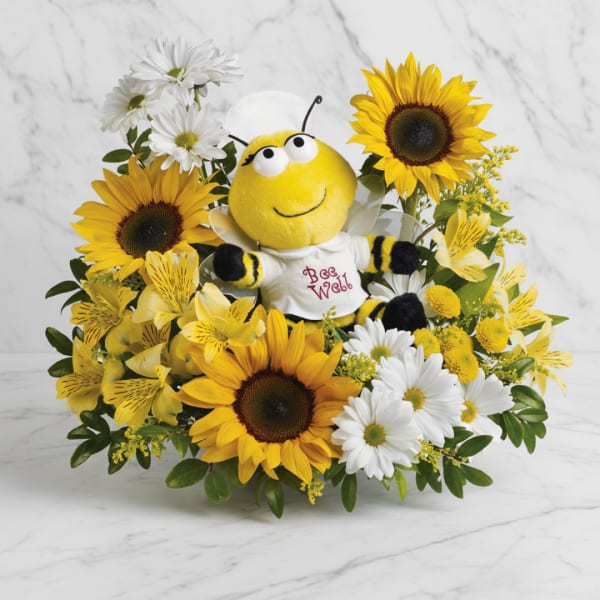 Sunflower and daisy arrangement with a plush bee in the center