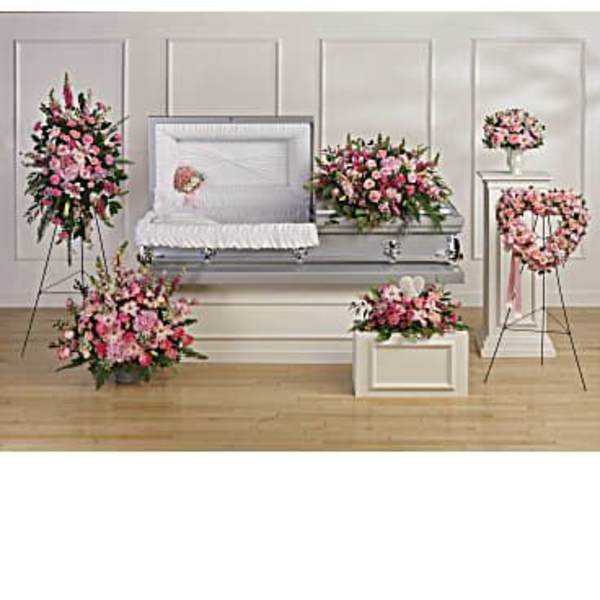 Funeral casket surrounded by pink floral sprays and wreaths