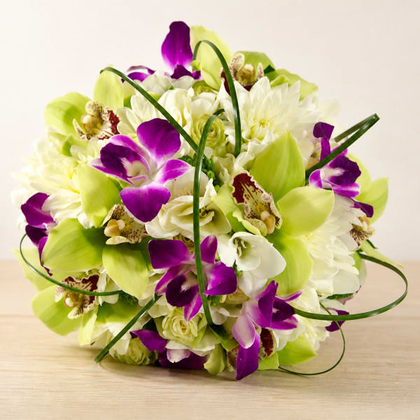 Purple orchids and white flowers arranged in a round bouquet