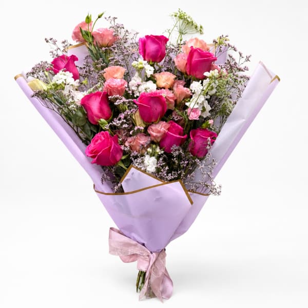 Bouquet of pink and white roses wrapped in lavender paper