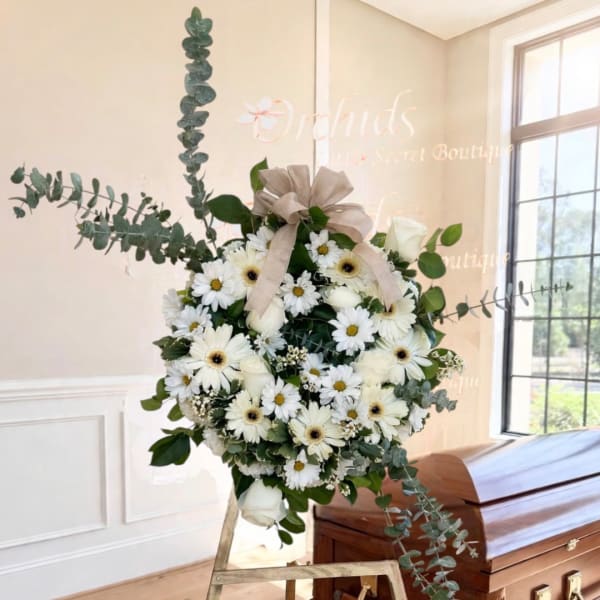 White daisy and rose arrangement with eucalyptus on a stand