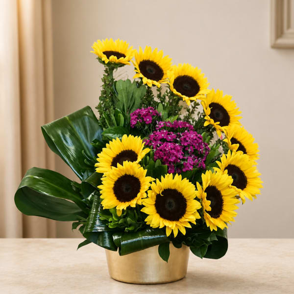 Sunflower arrangement with purple flowers in a gold container