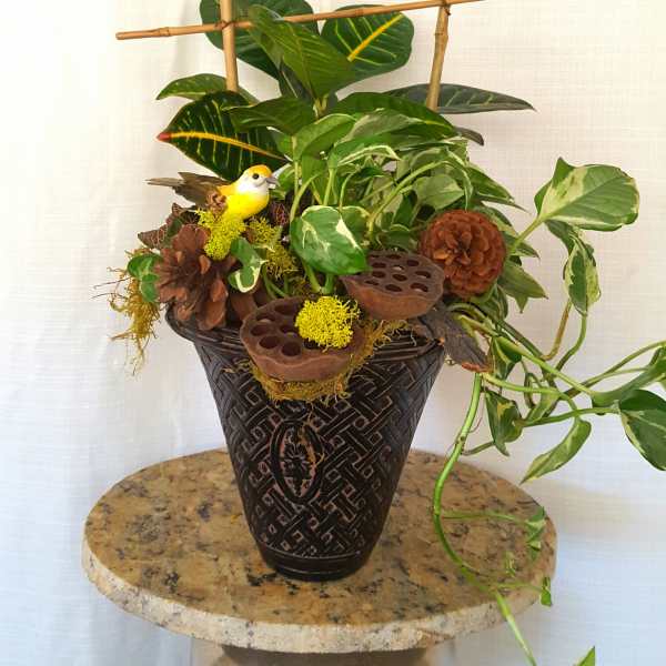 Potted plant arrangement with decorative birds and bamboo stakes