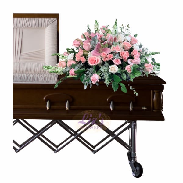 Pink floral casket spray with roses and lilies