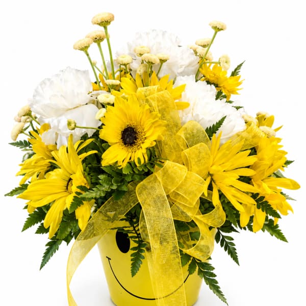 Yellow and white flower arrangement in a yellow smiley-face bucket