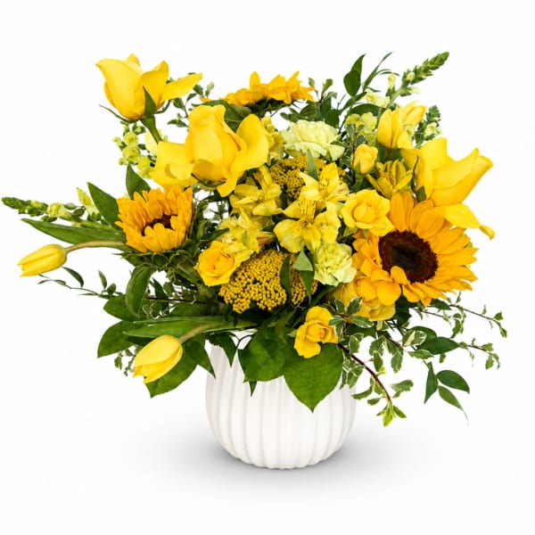 Yellow floral arrangement in a white vase with sunflowers, roses, and tulips