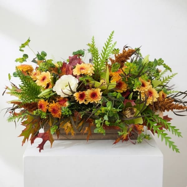 Autumn floral arrangement with yellow-orange blooms in a wooden box