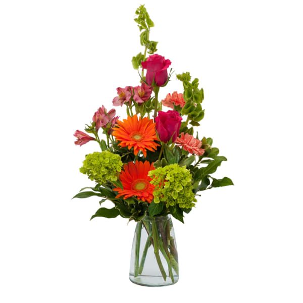 Mixed bouquet with orange gerbera daisies, pink roses, and green hydrangeas in a glass vase