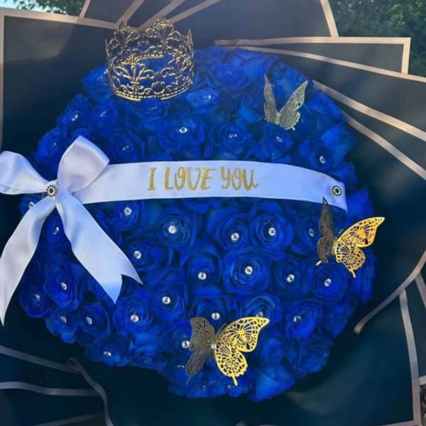Blue rose bouquet with a white ribbon and decorative crown