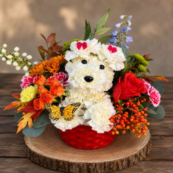 Flower arrangement in a red basket shaped like a bear face with a butterfly accent