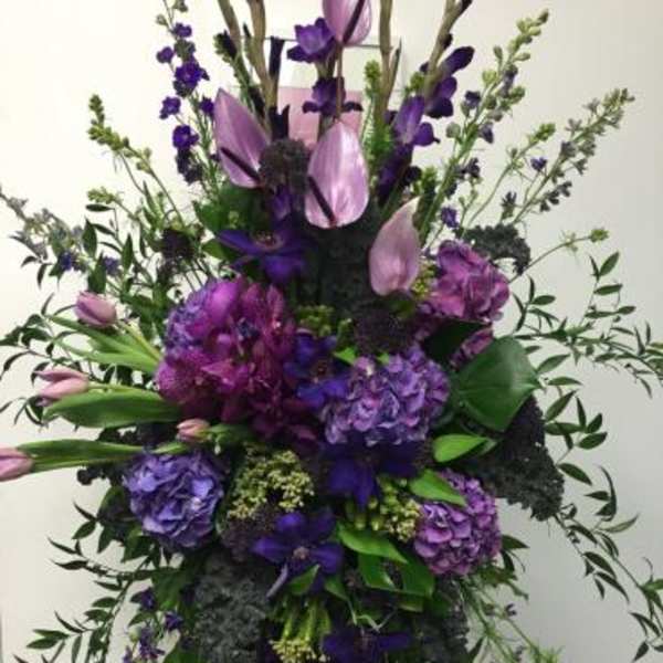 Tall purple floral spray with cascading greenery