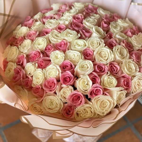 Bouquet of pink and cream roses wrapped in pale pink paper