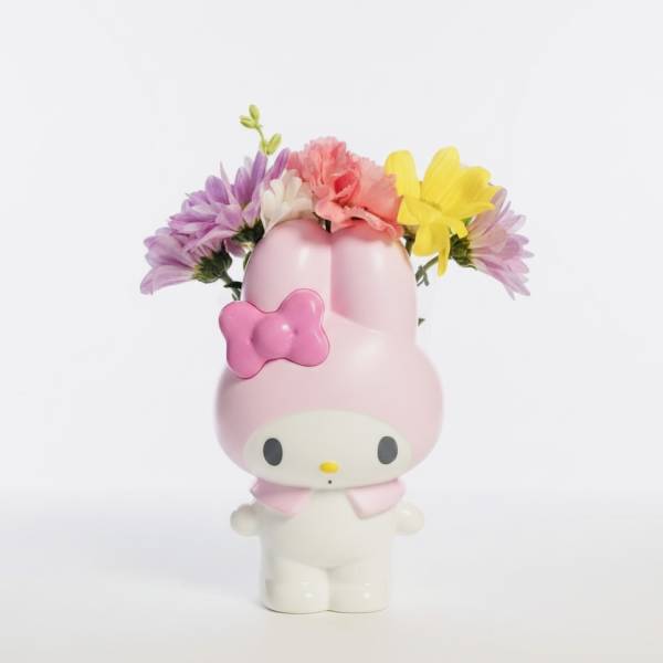 Pink Hello Kitty figurine holding a small bouquet of colorful flowers