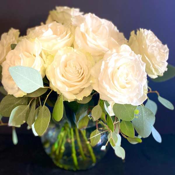 Bouquet of white roses with eucalyptus in a glass vase