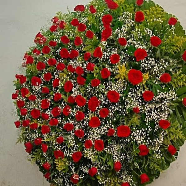 Large standing wreath of red roses with white filler flowers