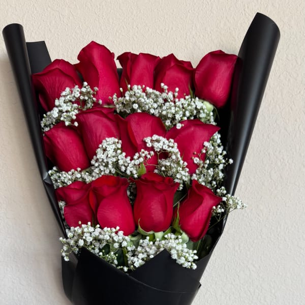 Bouquet of red roses with white baby's breath wrapped in black paper