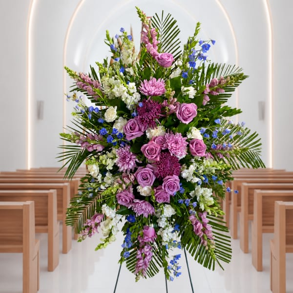 Large pink, white, and blue floral standing spray on an easel