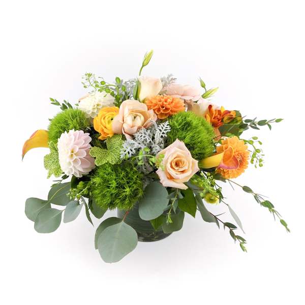 Mixed bouquet of peach, orange, and white flowers in a vase