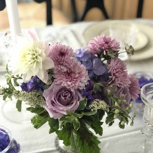 Lavender and pink floral centerpiece in a clear glass vase