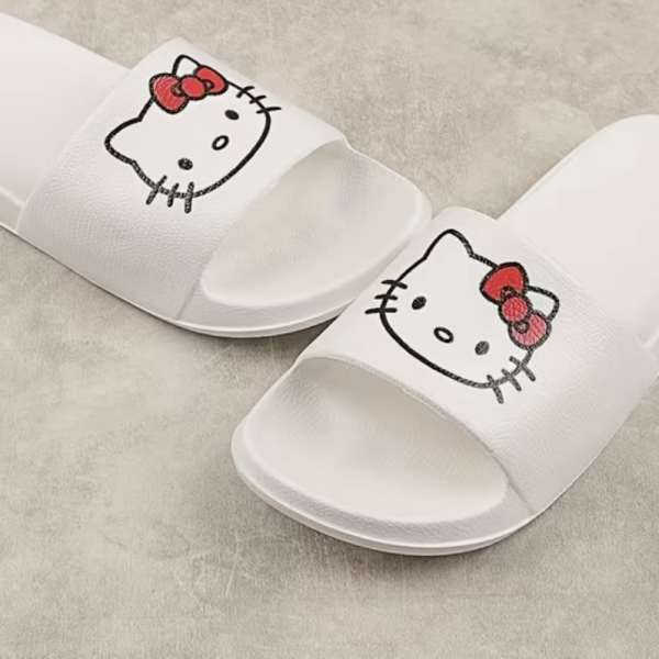 Pair of white slide sandals with Hello Kitty faces on the straps