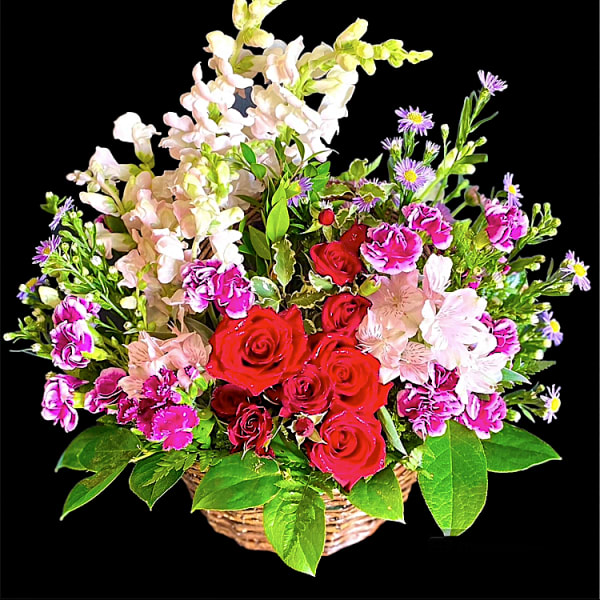 Basket of red roses, pink flowers, and purple daisies