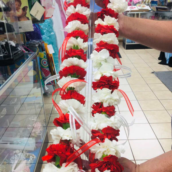 Red and white carnation garlands held on a clear stand