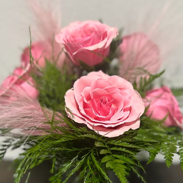 Pink roses arranged with airy greenery