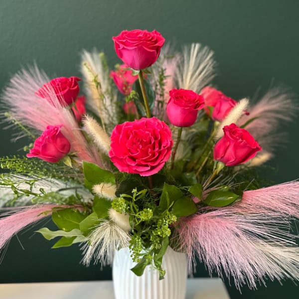 Pink roses and a pink carnation in a white vase