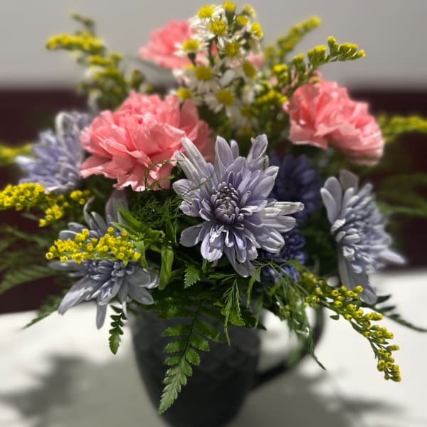 Pink and lavender flowers arranged in a dark vase