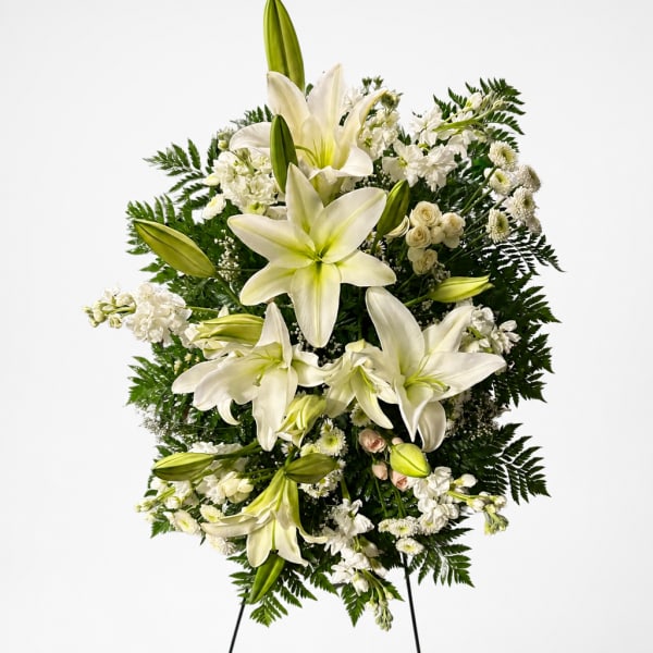 White lily and rose standing spray with greenery on a white background