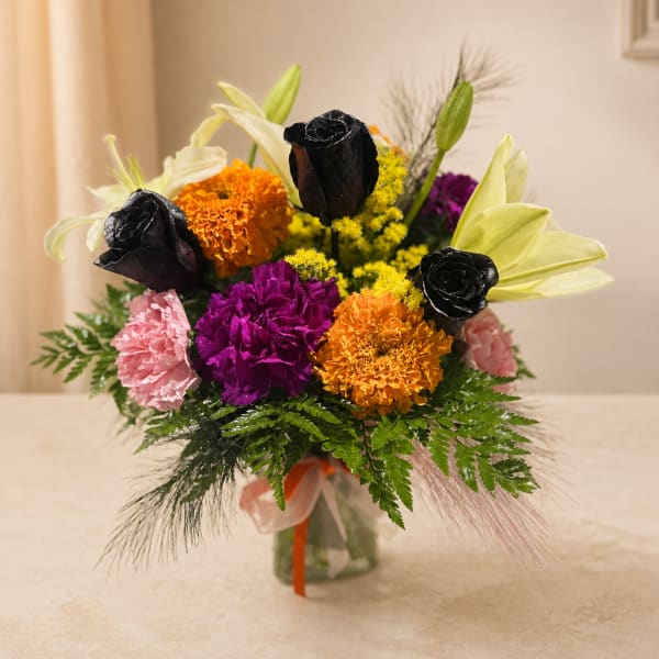 Colorful bouquet with lilies, roses, and carnations in a glass vase