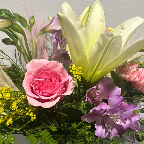 Pink rose and purple lilies in a mixed bouquet
