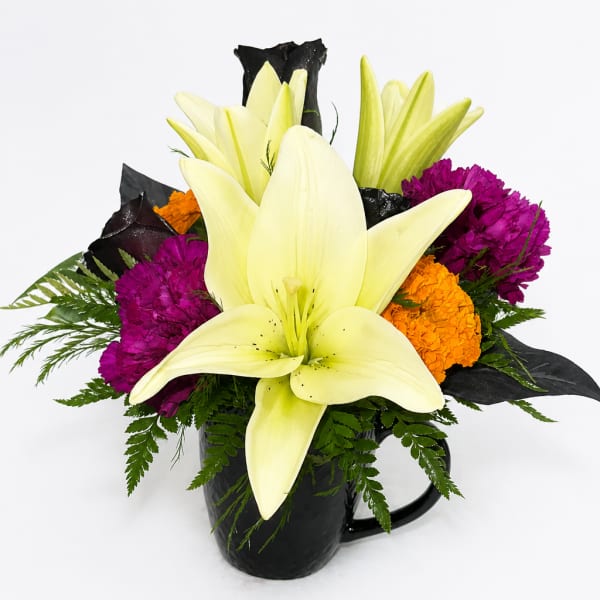 Yellow lilies and purple and orange flowers in a black mug