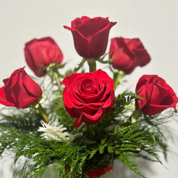 Bouquet of red roses with greenery in a vase