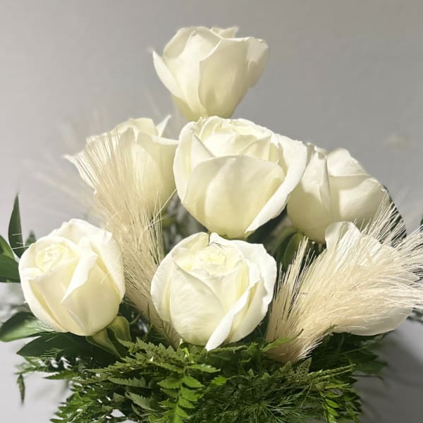 White rose bouquet with feathery beige accents and green foliage
