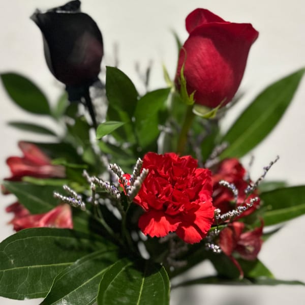 Red roses and carnations with greenery in a bouquet