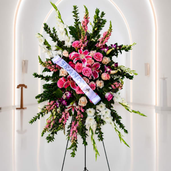 Large standing floral spray with pink and white flowers on an easel