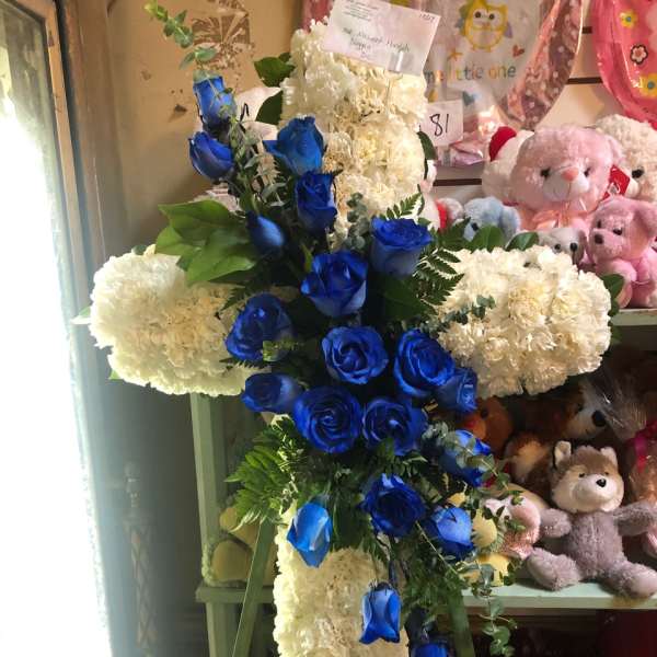 Cross-shaped floral arrangement with blue roses and white carnations