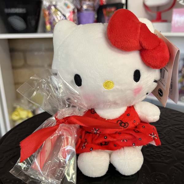 Hello Kitty plush toy in a red dress with a candy cane and ribbon