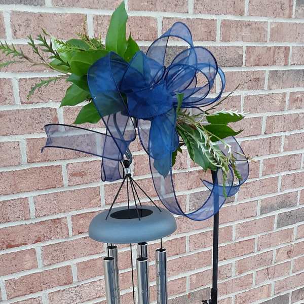 Blue ribbon wind chime with greenery and metal tubes on a stand