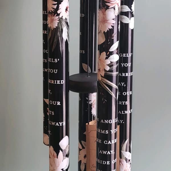 Black hanging wind chime with floral-printed tubes and a round top