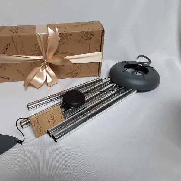 Gift box with ribbon and several metal wind chimes with tags