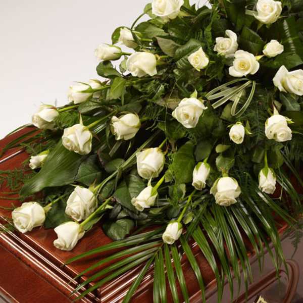 White roses arranged on a wooden casket