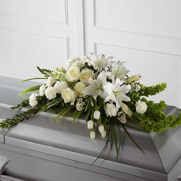 White floral casket spray with roses and lilies