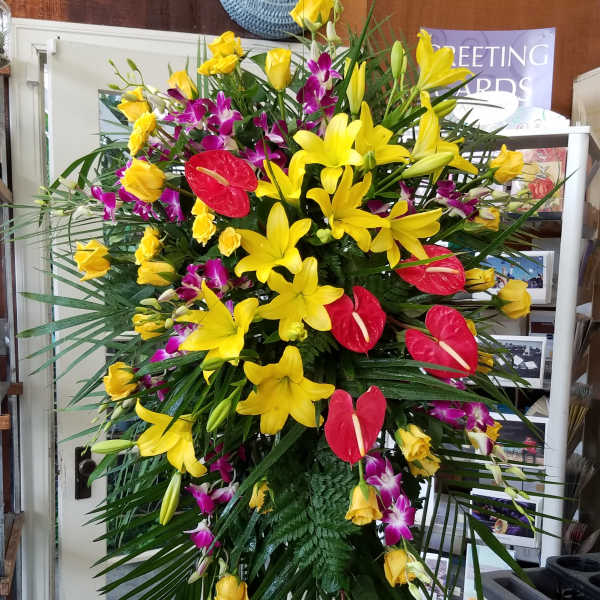 Tall standing floral spray with yellow lilies, red anthuriums, and purple orchids