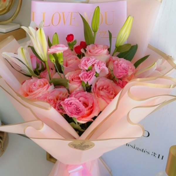 Pink rose bouquet with white lilies wrapped in pale pink paper